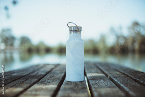 Close-up of a water bottle on a table by a river photo