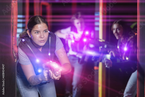 Young lady having fun playing lasertag in arena