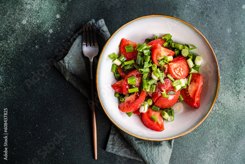 Overhead view of a bowl of tomato and spring onion salad