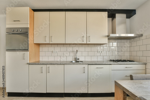a kitchen with white cabinets and black counter tops on the island in front of the sink is an oven  dishwasher and microwave