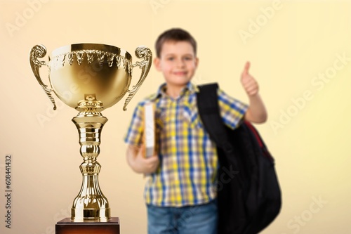 Excited young student with victory trophy