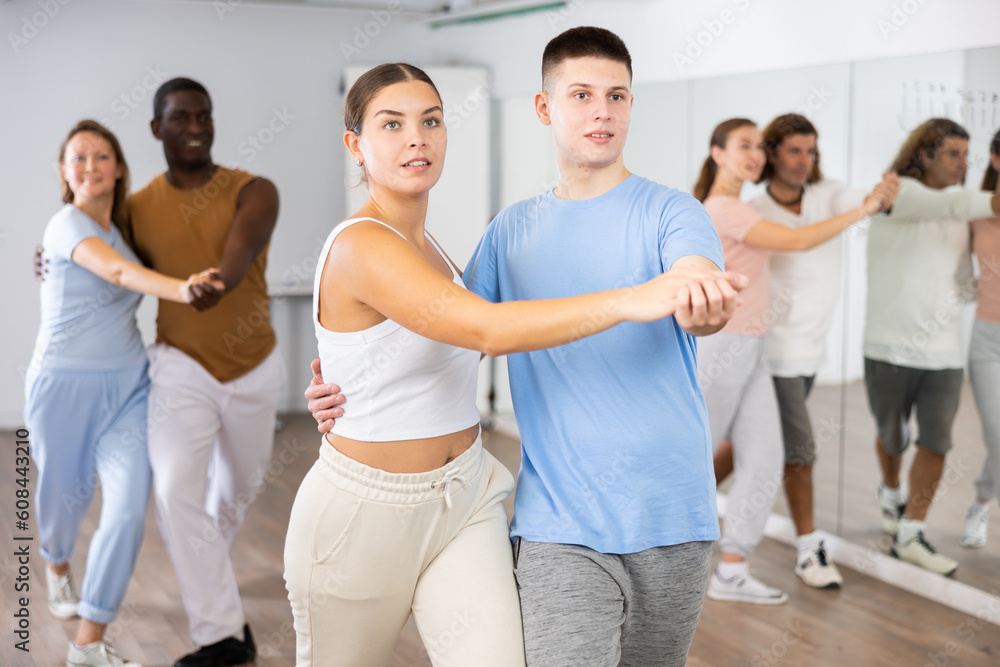 Couple woman and teen boy rehearsing pair dance in dance studio