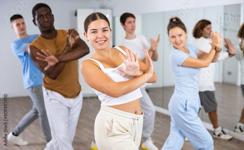 Group of active women and men practicing energetic dance in a modern dance studio