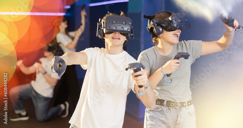 Young guy and girl in vr headset stand shoulder to shoulder interacting with digital interface.Students is testing equipment for training, games, entertainment in virtual reality