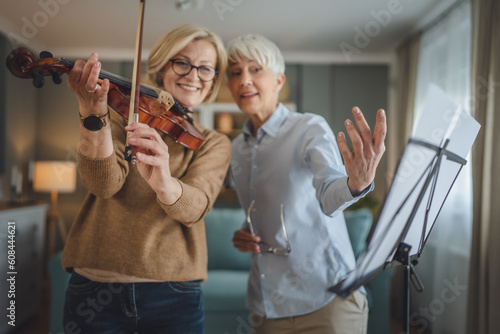 Private music teacher give violin lesson mature senior woman at home