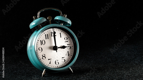 Reloj despertador retro de mesa azul de los años 80. Marcando la hora. Fotografía horizontal apaisada. Aislada sobre fondo negro. Espacio para texto photo