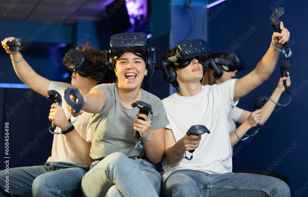 Modern young people wearing virtual reality headset playing video games together