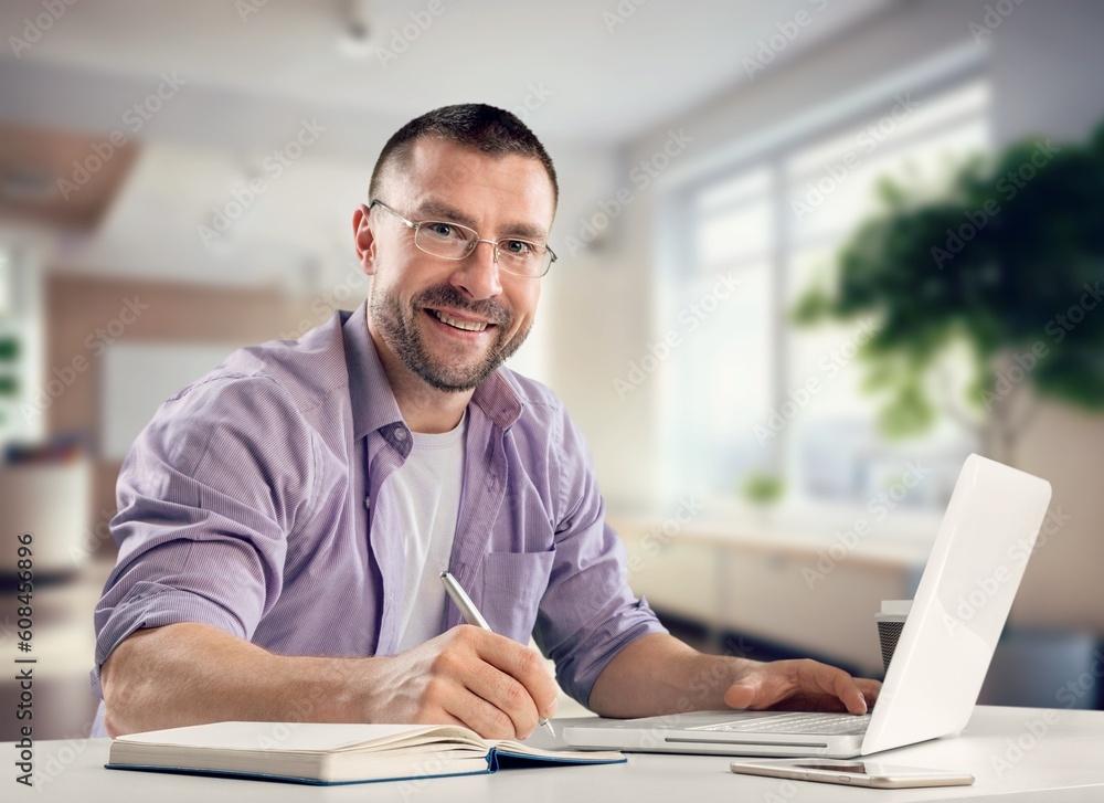 Happy young business man using laptop