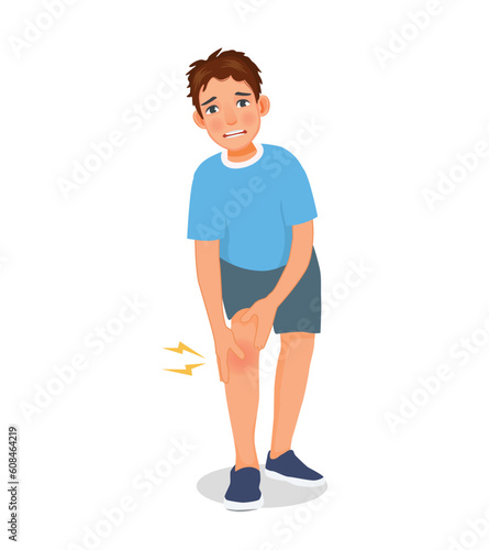 Young man suffering from knee pain holding his injured leg while exercising