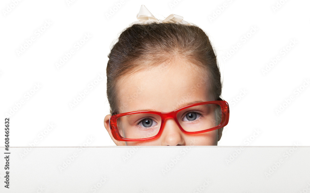 Girl in red-framed eyeglasses looking up from behind the table Girl in red-framed eyeglasses looking up from behind the table