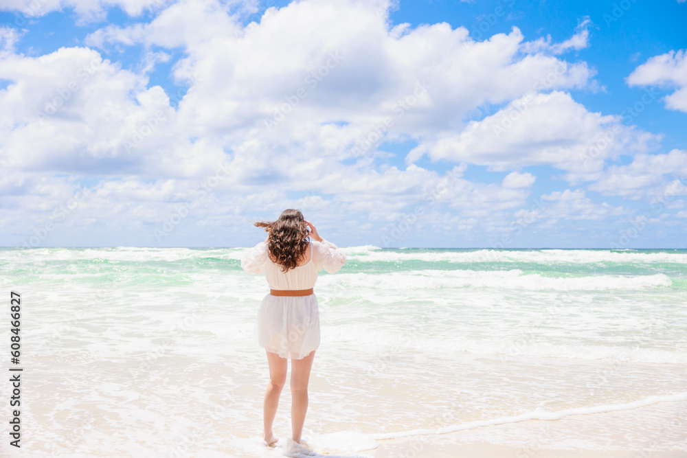 白ワンピースで海を見つめる女性の後ろ姿(全身) 白ワンピースで海を見つめる女性の後ろ姿(全身)