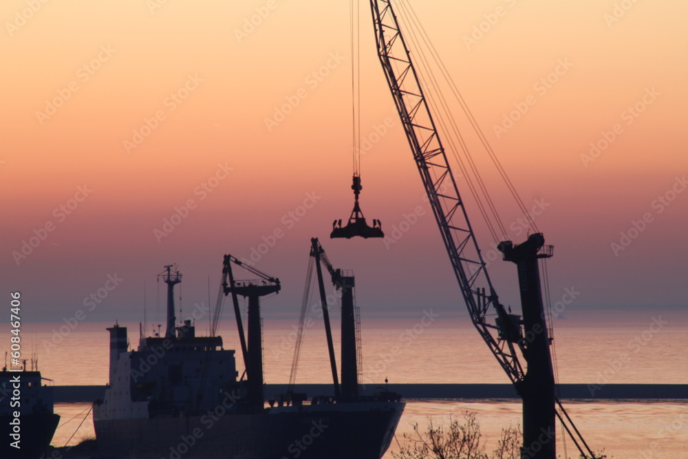 Sunrise at the pier with a crane silhouette