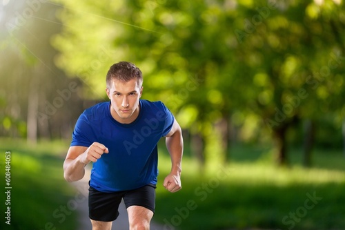 Happy young man running in city park