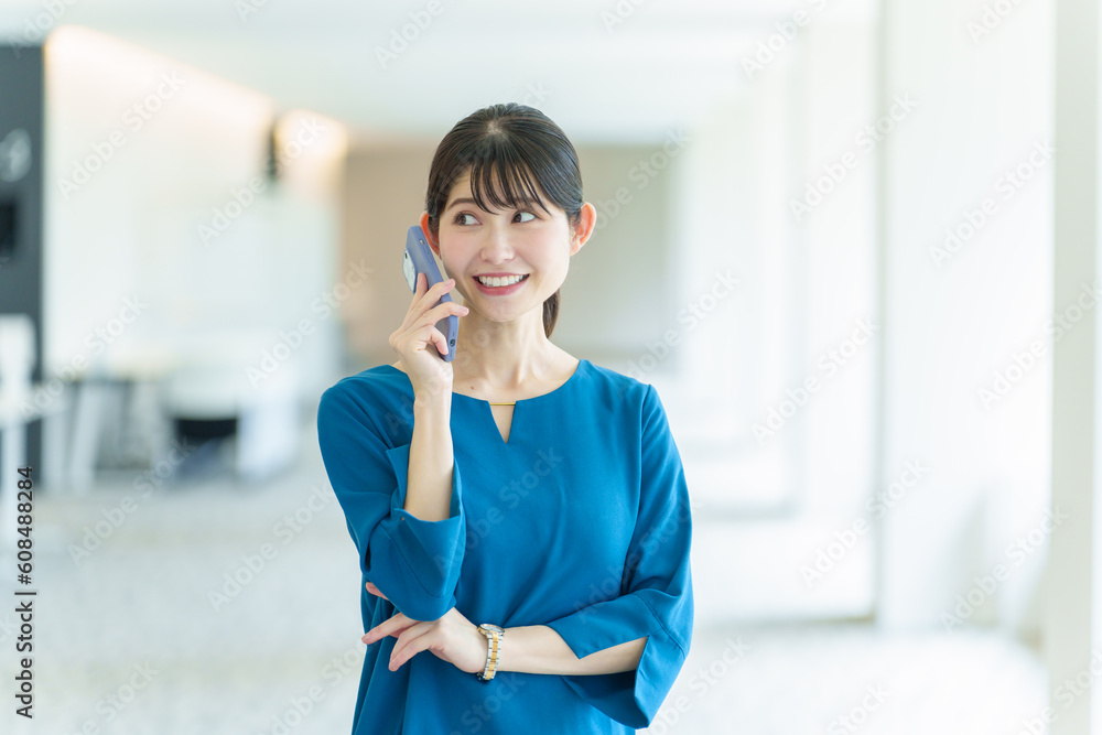 Fototapeta premium オフィスで電話をするビジネスウーマン