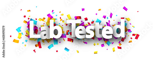 Lab tested sign with colorful cut out ribbon confetti background.