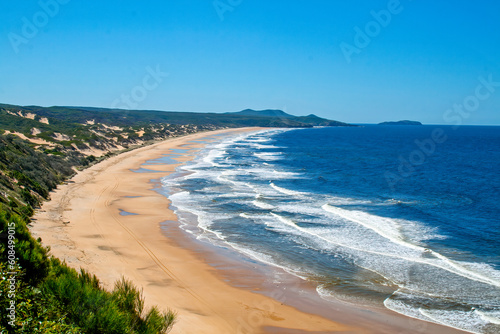 A curved sandy bay with waves breaking on the beach on the East coast of Australia