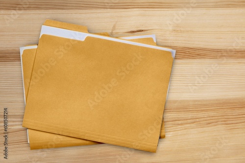 Yellow office file with documents on wooden table