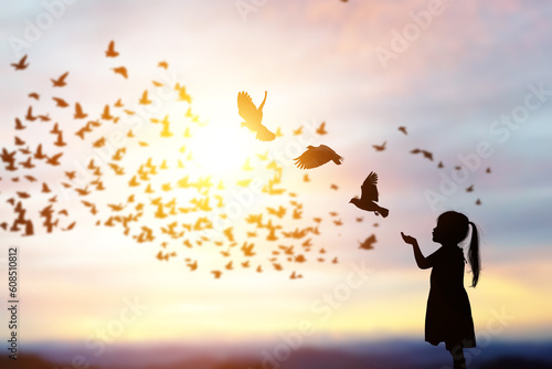 Fototapeta Naklejka Na Ścianę i Meble -  silhouette of bird flying out of Girl child hand on beautiful background.freedom concept ,International Working Women's Day
