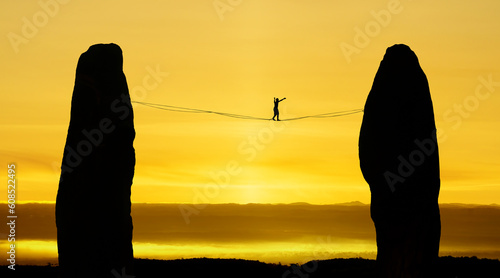 Silhouette of tightrope walker balancing on the rope