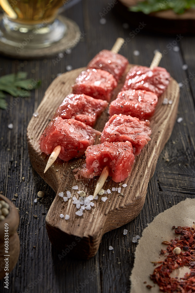 Fresh raw beef on skewers on a wooden cutting Board. Raw kebab.
