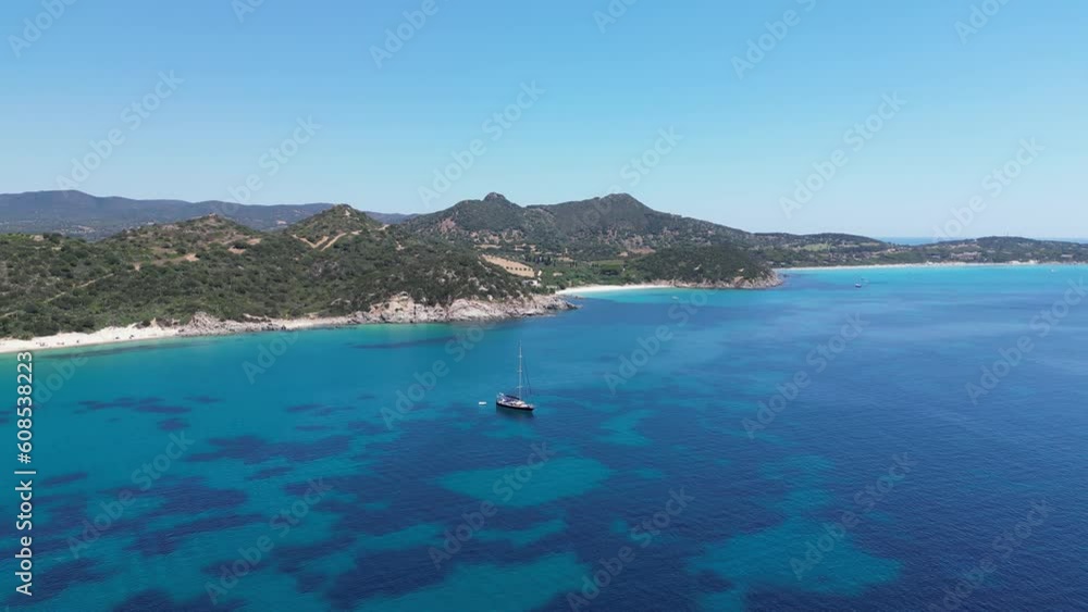 Boat moored in a beautiful bay with blue sea. Sardinia, Italy. Aerial backward view Boat moored in a beautiful bay with blue sea. Sardinia, Italy. Aerial backward view
