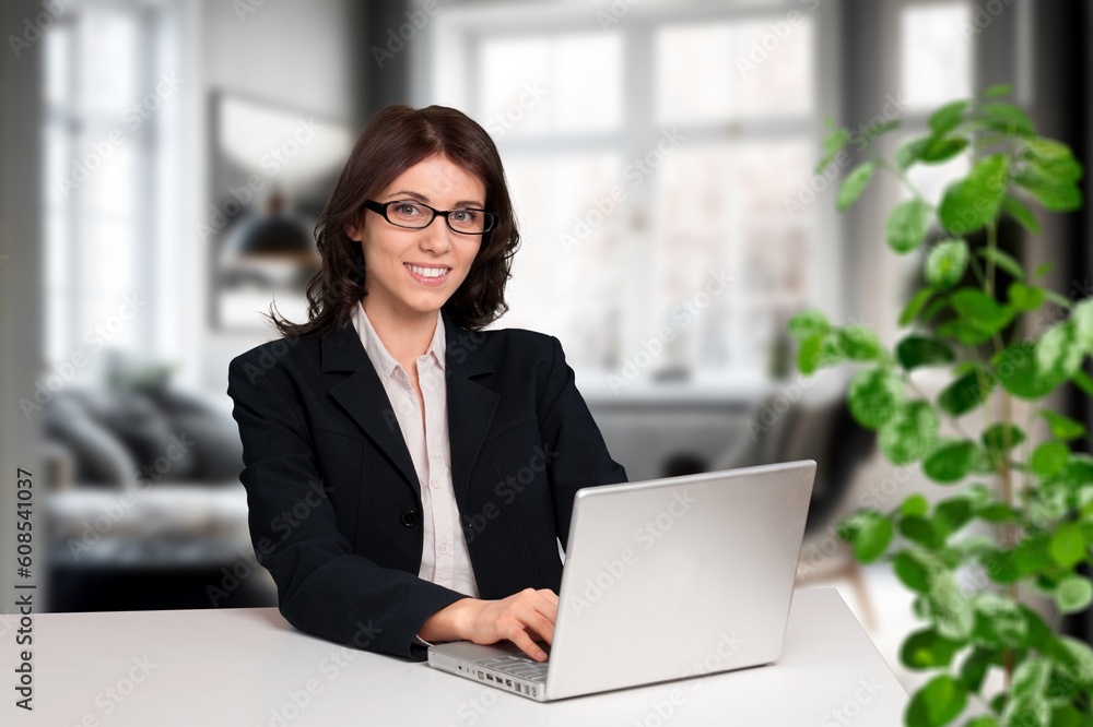 Happy woman works on laptop in home office Happy woman works on laptop in home office