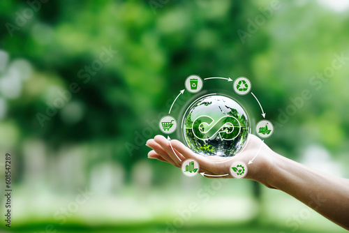 Hand-holding crystal globe with icon circular economy for carbon credit and CO2 emissions reduction. materials and products to reuse and renewable material resources, reuse, renewable, and repair,