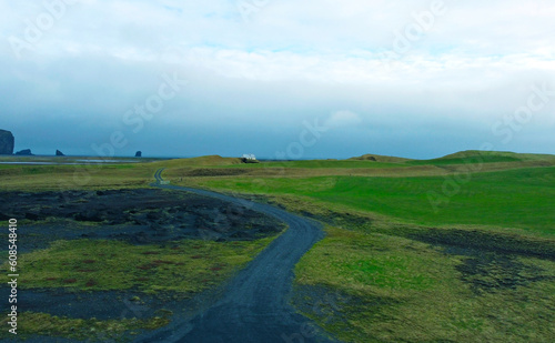 Aerial view of the beautiful northern road in the middle of the green field of Iceland. Photography for tourism background, design and advertising © Payllik