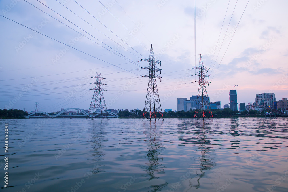  High voltage power line in the city with beautiful sky and water reflection landscape view in hatirjheel lake in Bangladesh
