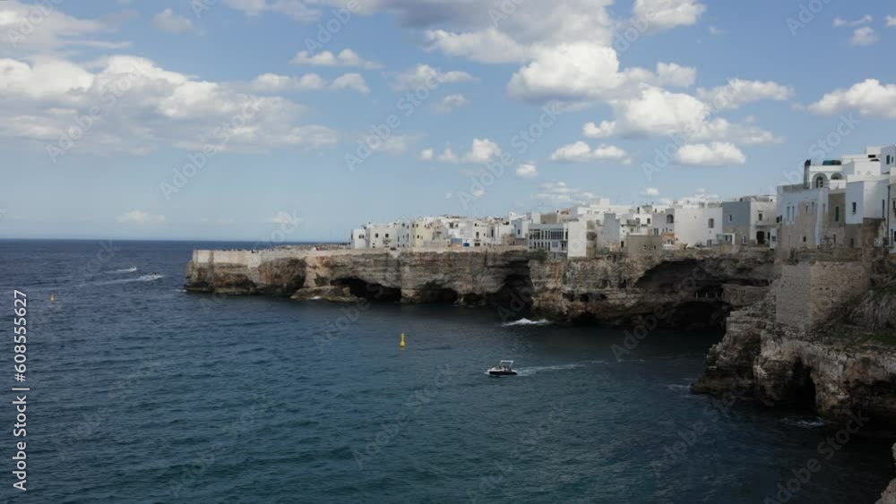 Tourism boat tour near rocky coast with white buildings in Polignano, Puglia, Italy Tourism boat tour near rocky coast with white buildings in Polignano, Puglia, Italy
