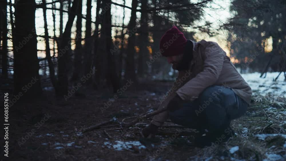 A man searching for firewood to start a campfire A man searching for firewood to start a campfire