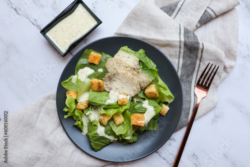 Caesar Salad with sliced of breast chicken meat flat lay on marble table 