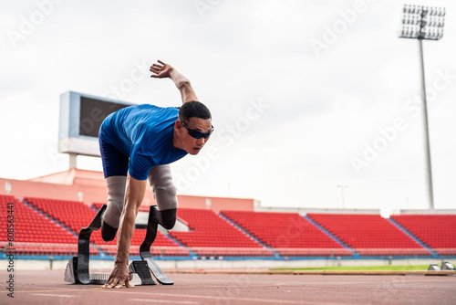 Asian para-athletes disabled with prosthetic blades running at stadium. © Kawee