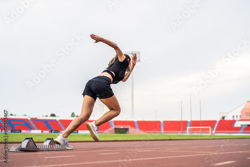 Asian young sportswoman sprint on a running track outdoors on stadium