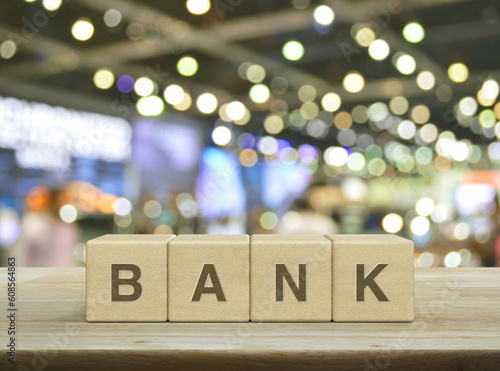 Bank letter on wood block cubes on wooden table over blur light and shadow of shopping mall, Business banking service concept © grapestock