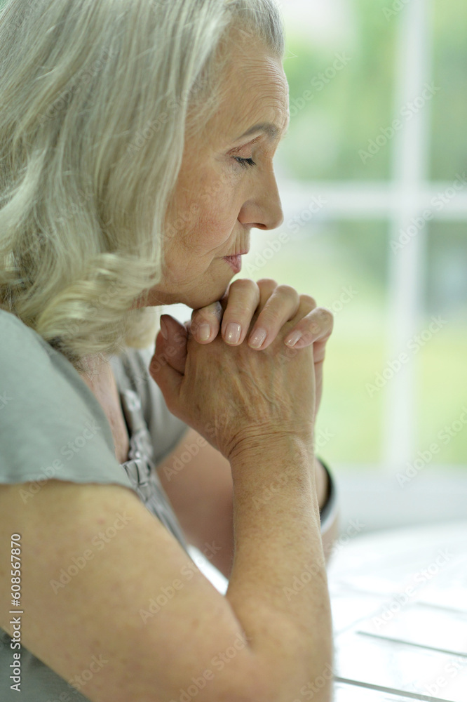 Close up portrait of sad old woman praying Close up portrait of sad old woman praying