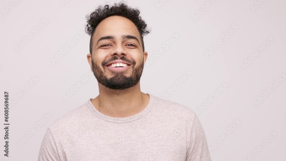 Portrait of a smiling young professional man standing in front of white background looking at camera, laughing and being happy Portrait of a smiling young professional man standing in front of white background looking at camera, laughing and being happy