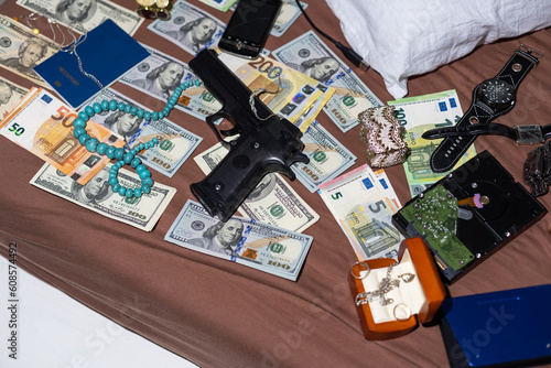 Police handcuffs lies on a set of green monetary denominations of 100 euros. A lot of money forms an infinite heap