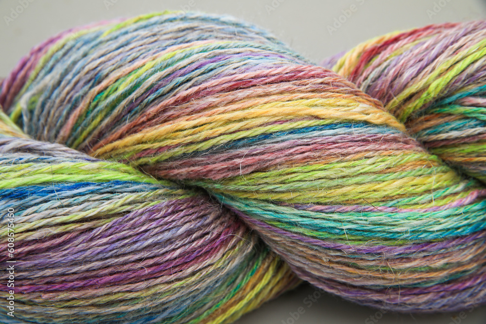 Closeup detail of a colourful skein of organic natural handspun and handdyed merino sheep wool, silk, linnen mix yarn fleece, spun on a traditional spinning wheel	