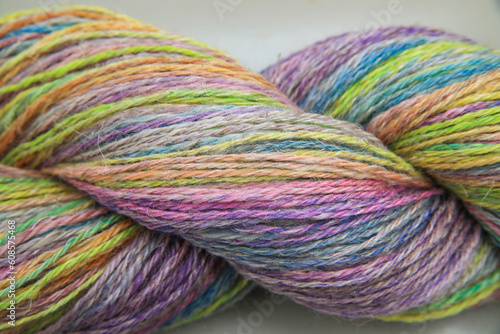 Closeup detail of a colourful skein of organic natural handspun and handdyed merino sheep wool, silk, linnen mix yarn fleece, spun on a traditional spinning wheel	
