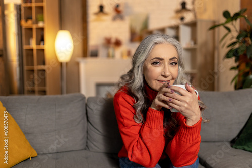 Gray-haired pretty senior woman with a cup in hands