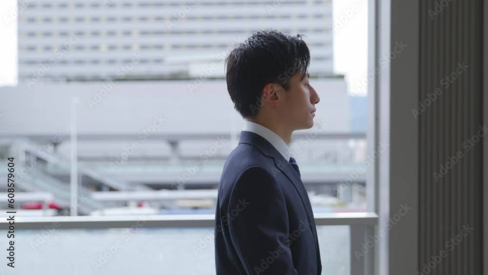 スーツを着て歩く若い日本人ビジネスマンのスローモーションイメージ スーツを着て歩く若い日本人ビジネスマンのスローモーションイメージ