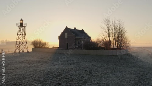 Aerial view of Gasthuis De Lichtwachter at Schokland during misty sunrise, drone shot photo