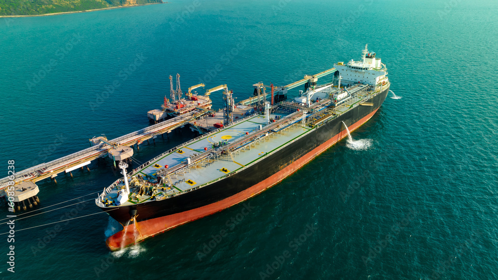 crude oil floating station in sea, bridge pipeline load unloading crude oil from oil ship transport, industry business transportation by container ship open sea, aerial drone point of view
