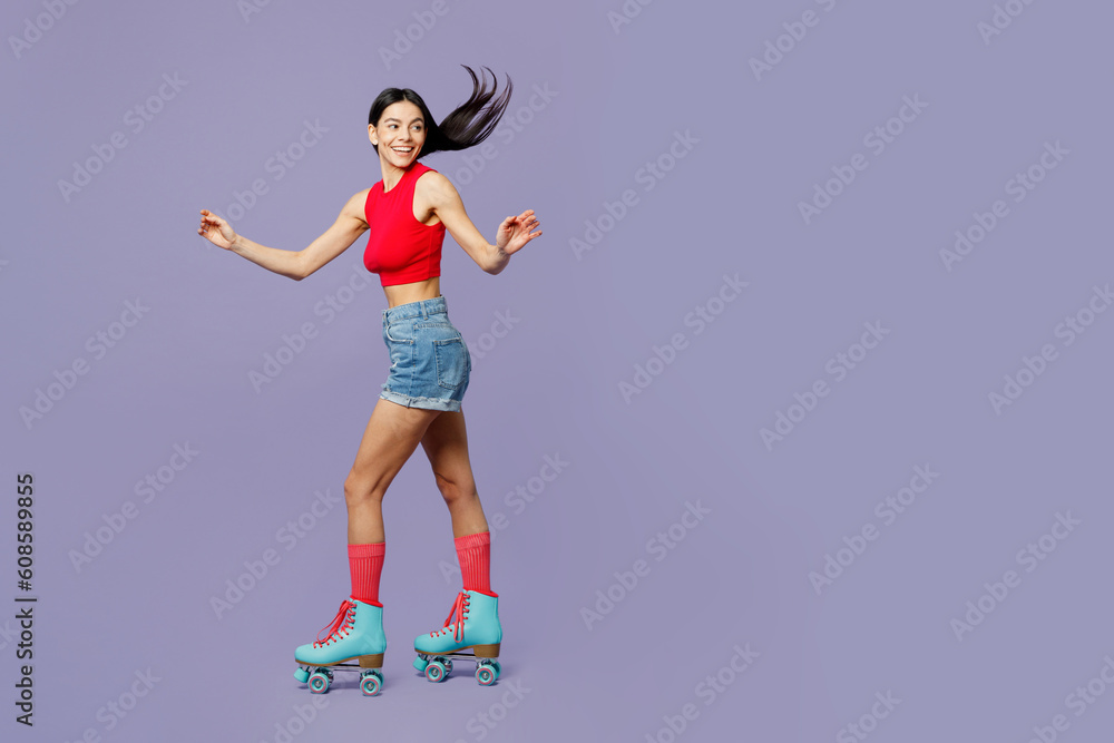 Full body side view happy cheerful active cool young latin woman she wear red casual clothes rollers rollerblading isolated on plain pastel purple background. Summer sport lifestyle leisure concept.