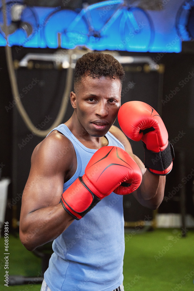  African-American athlete prepared for combat, wearing boxing gloves and in the classic defensive position. 