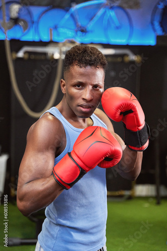  African-American athlete prepared for combat, wearing boxing gloves and in the classic defensive position. 