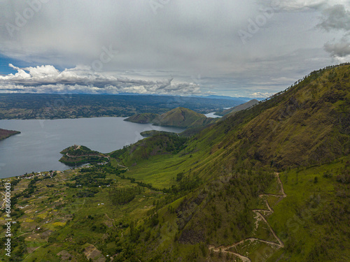 Aerial drone of mountains with forest and Lake Toba. Samosir Island. Sumatra, Indonesia. © Alex Traveler