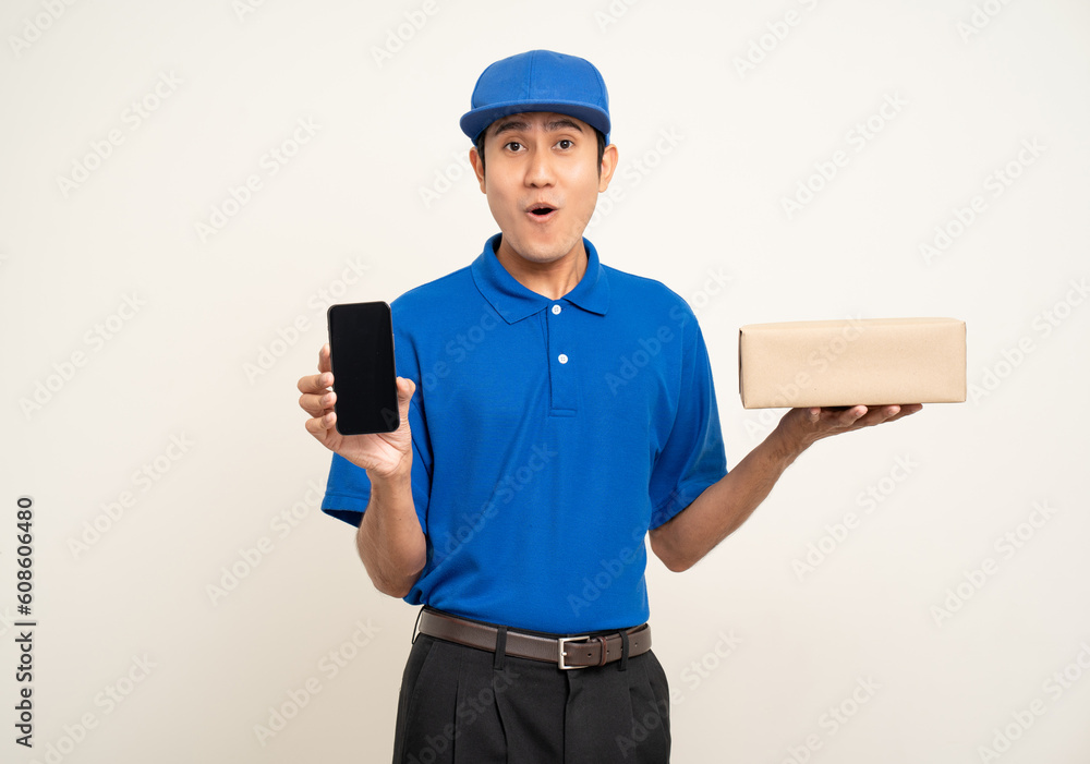 Asian man in blue uniform standing holding box parcel cardboard and smartphone on isolated white background. Male service worker with cell phone. Delivery courier shipping service Asian man in blue uniform standing holding box parcel cardboard and smartphone on isolated white background. Male service worker with cell phone. Delivery courier shipping service