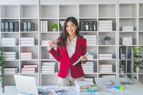 Asian happy beautiful businesswoman in formal suit work in workplace. Attractive female employee office worker smile.